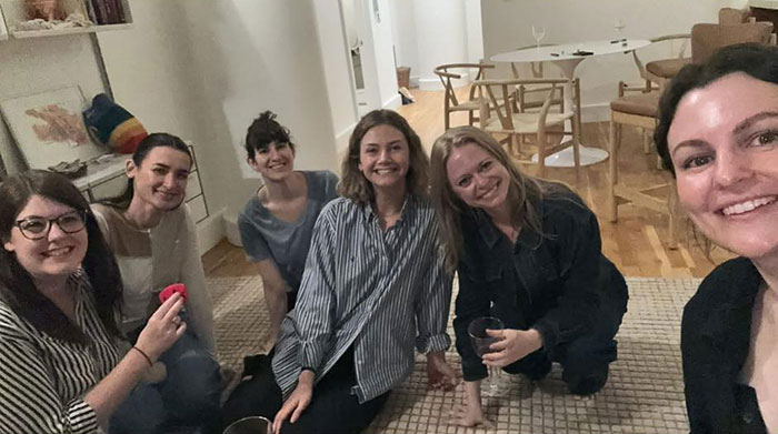 A group of women sitting on the floor in a Brooklyn midwife’s dice game club raising safety concerns for non-white women.