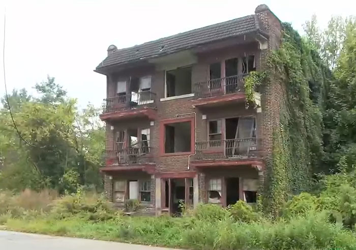 Abandoned brick building overgrown with vegetation, setting scene for cop opening fire on teens over porta-potty prank debate. Abandoned brick building overgrown with vegetation, setting scene for cop opening fire on teens over porta-potty prank debate.