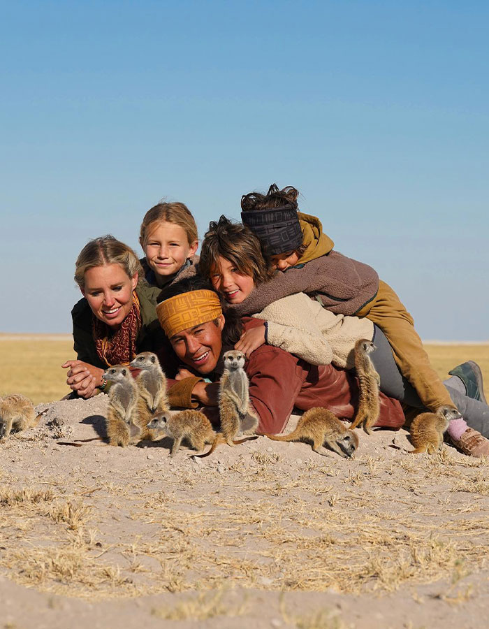 Group of people lying on the ground observing meerkats in an open field, unrelated to dad throwing 7YO son off cliff story. Group of people lying on the ground observing meerkats in an open field, unrelated to dad throwing 7YO son off cliff story.