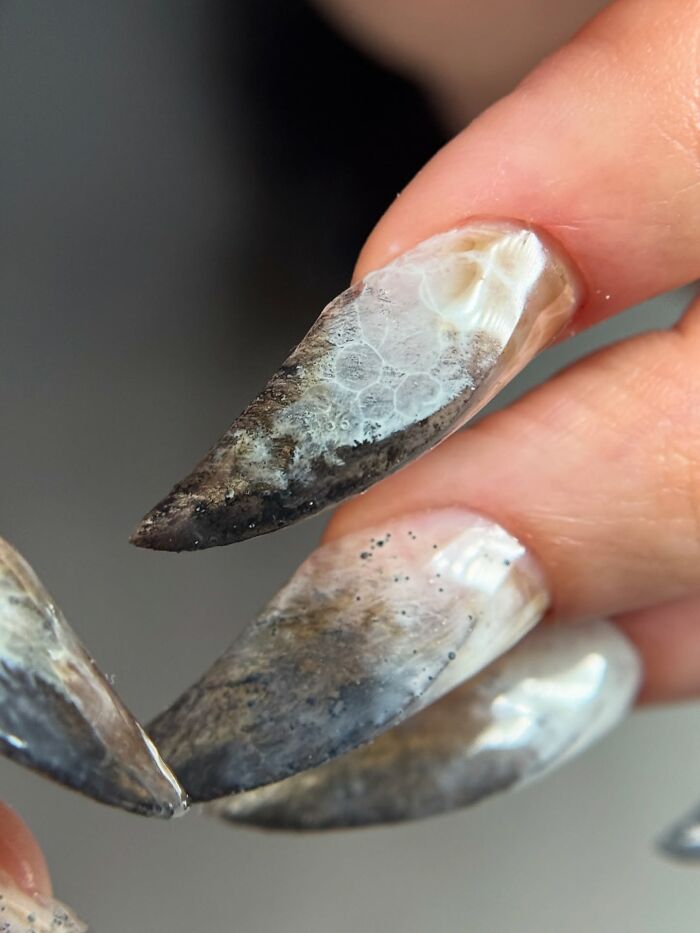 Long stiletto nail designs with smoky, translucent patterns and textured details creating an edgy, rule-breaking look.