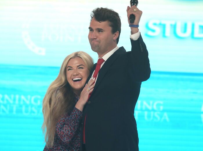 Erika Kirk smiling and holding a man in a suit raising a fist, capturing the gesture that sparked viral claim online. Erika Kirk smiling and holding a man in a suit raising a fist, capturing the gesture that sparked viral claim online.