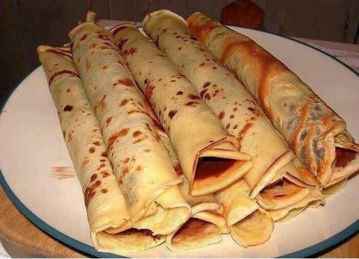 Traditional Eastern European rolled pancakes stacked on a plate, a nostalgic snack only people raised in Eastern Europe know well