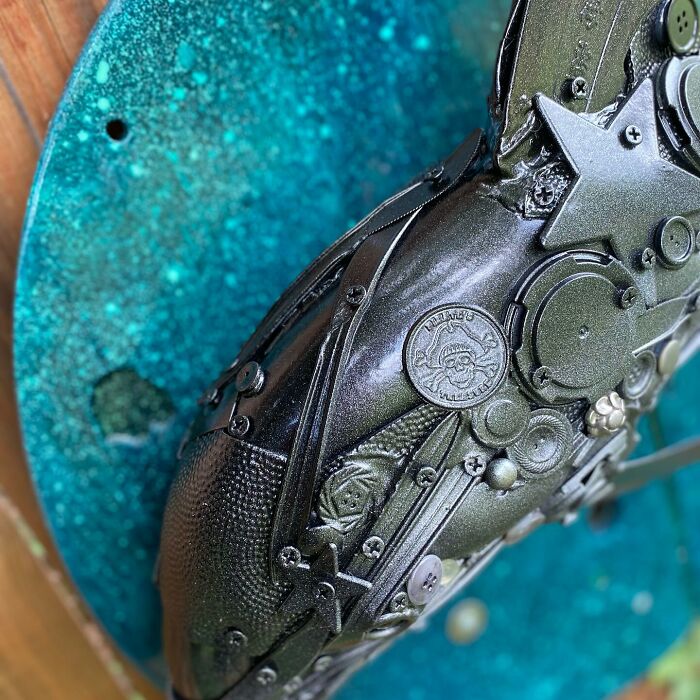 Metal dolphin sculpture made from trash and recycled items, showcasing stunning animal art with intricate details.