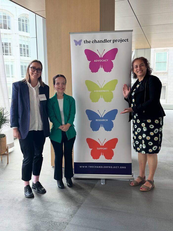 31YO woman with dwarfism standing beside advocacy banner with two other women at an indoor event. 31YO woman with dwarfism standing beside advocacy banner with two other women at an indoor event.