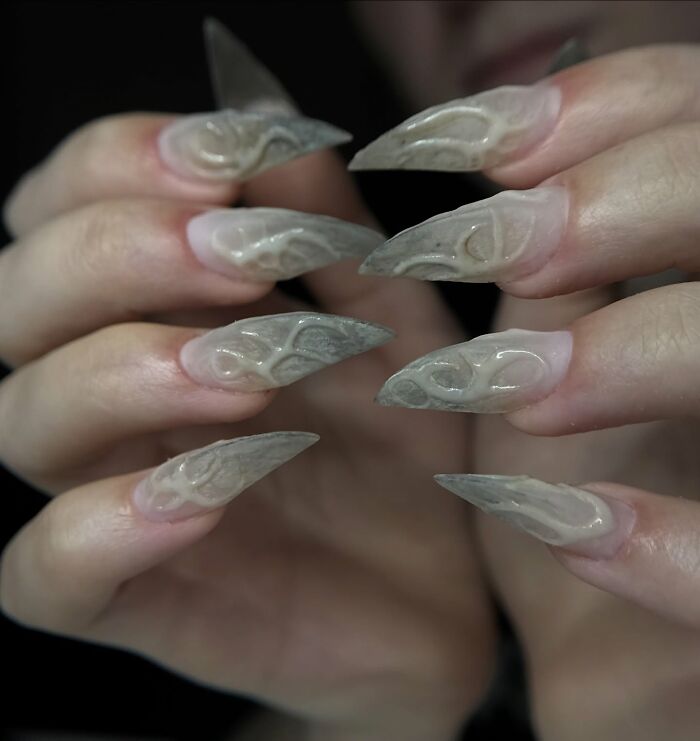 Long stiletto nail designs with translucent flame patterns creating a bold and unique nail art look.