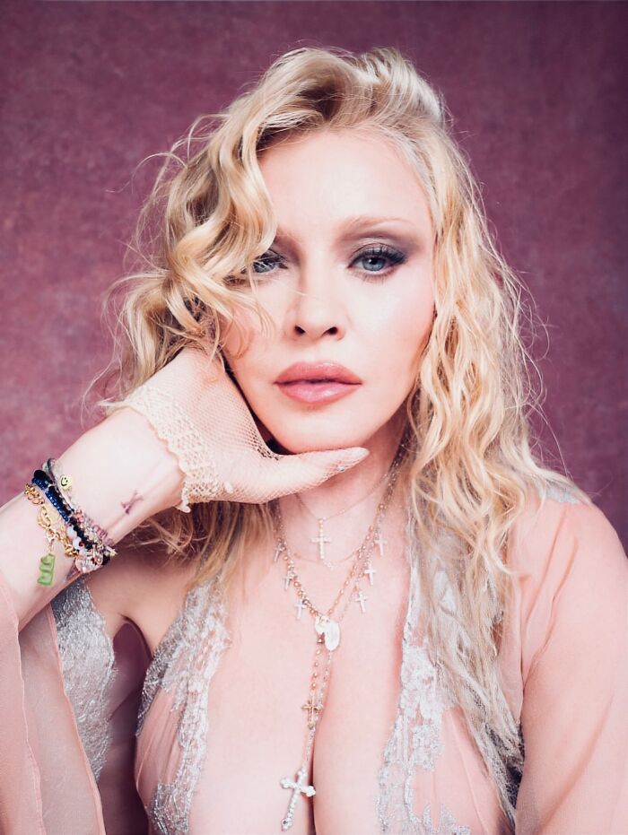 Madonna posing in a sheer lace dress with layered cross necklaces and wavy blonde hair in a sizzling photo shoot. Madonna posing in a sheer lace dress with layered cross necklaces and wavy blonde hair in a sizzling photo shoot.