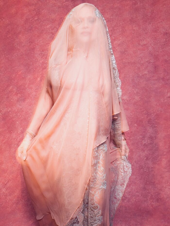 Madonna in a sheer lace dress and veil posing against a pink backdrop during a sizzling photo shoot. Madonna in a sheer lace dress and veil posing against a pink backdrop during a sizzling photo shoot.