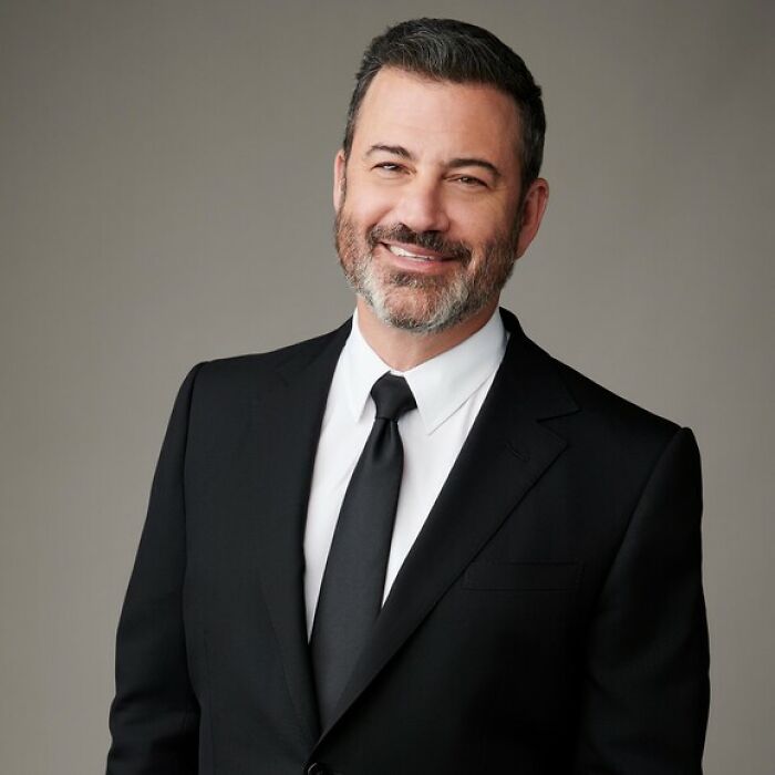 Jimmy Kimmel smiling in a black suit and tie, marking his return after show suspension over remarks controversy. Jimmy Kimmel smiling in a black suit and tie, marking his return after show suspension over remarks controversy.