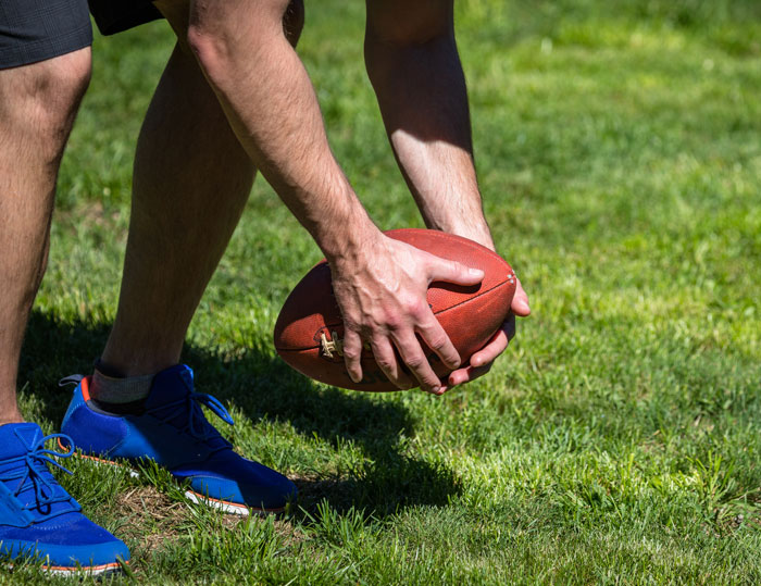 Man in blue sneakers holding football on grass, illustrating the lesson learned by woman who gave husband another chance Man in blue sneakers holding football on grass, illustrating the lesson learned by woman who gave husband another chance