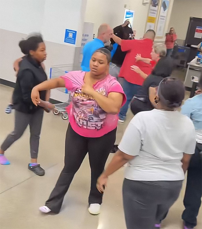 Angry mob inside Walmart confronting employee with tense gestures during chaotic scene in store aisles. Angry mob inside Walmart confronting employee with tense gestures during chaotic scene in store aisles.