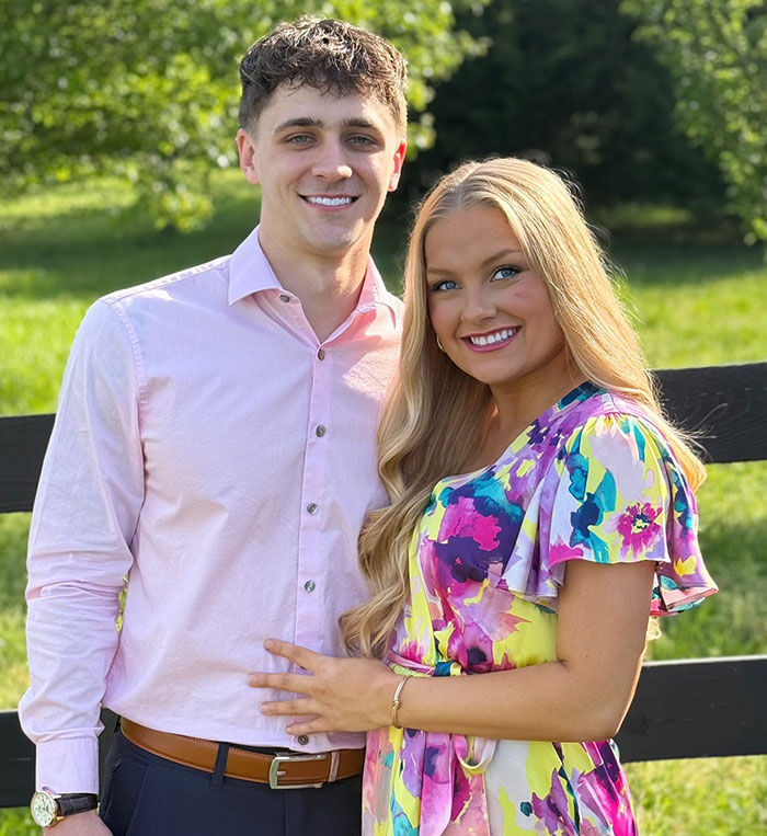 Young couple smiling outdoors in bright sunlight, related to cheerleader dropping out of university after newborn found in closet Young couple smiling outdoors in bright sunlight, related to cheerleader dropping out of university after newborn found in closet