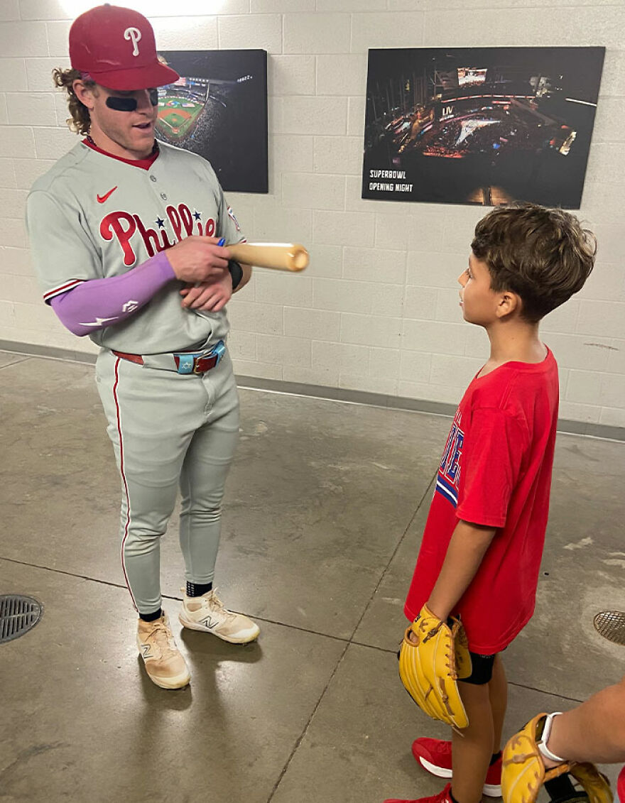 Phillies player signing a bat for a young fan, relating to woman mistaken for Phillies Karen after home run ball incident. Phillies player signing a bat for a young fan, relating to woman mistaken for Phillies Karen after home run ball incident.