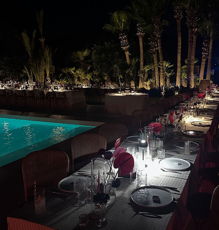 Outdoor nighttime dining setup by pool with elegant table settings and dim ambient lighting, capturing Sacha Baron Cohen event ambiance Outdoor nighttime dining setup by pool with elegant table settings and dim ambient lighting, capturing Sacha Baron Cohen event ambiance