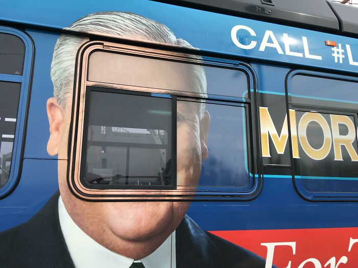 Bus advertising placement fail showing a man’s face humorously distorted by the window design causing a laugh.