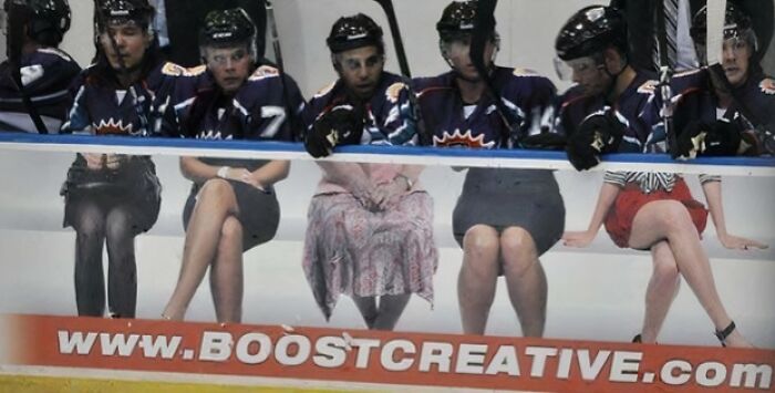 Hockey players sitting behind an ad banner where the placement creates a humorous optical illusion, an advertising placement fail.