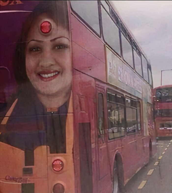 Double-decker bus with a large face ad creating an unintended funny advertising placement fail on the street.