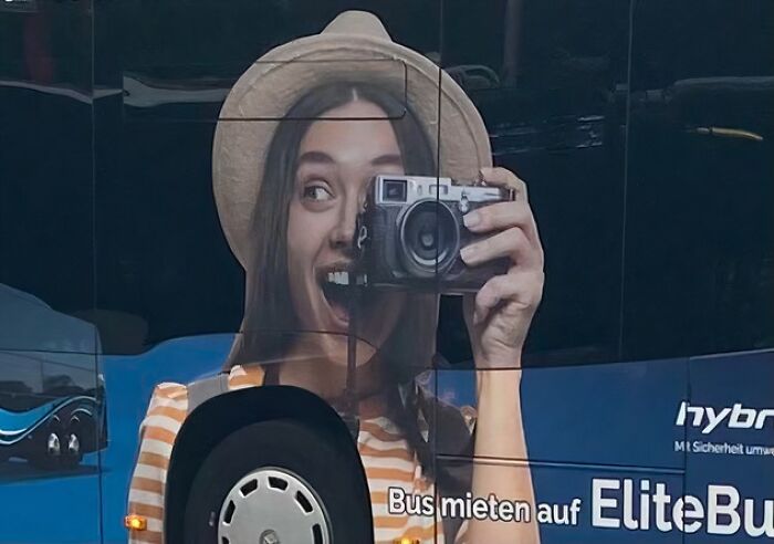 Bus advertisement placement fail showing a distorted smiling woman with a camera causing a humorous visual effect.
