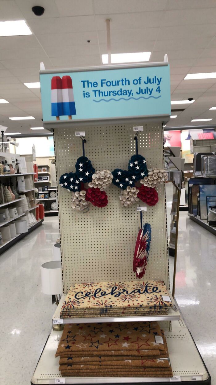 Store display of Fourth of July decorations including star-shaped wreaths and patriotic rugs with social media marketing fail signage above.