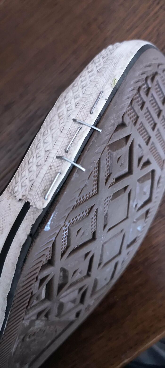 Close-up of a shoe sole repaired with staples, showcasing a creative redneck engineer fix in everyday life.