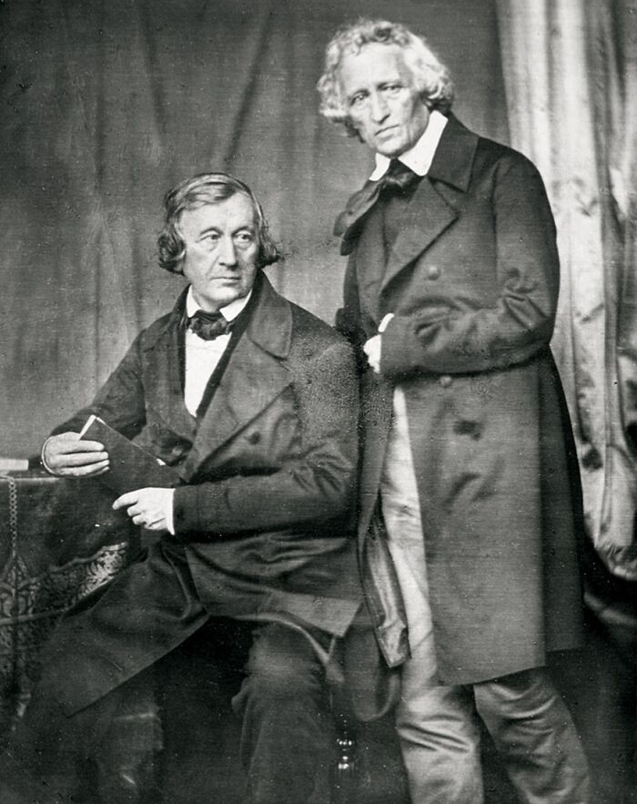 Two men in 19th century clothing pose for a black and white photo illustrating false history facts.