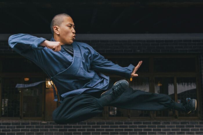 Martial artist performing a high jump kick in traditional clothing, illustrating facts about history that turned out false.