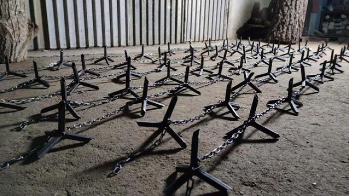 Metal caltrops arranged in rows on the ground, representing chaotic good actions in an unusual way.