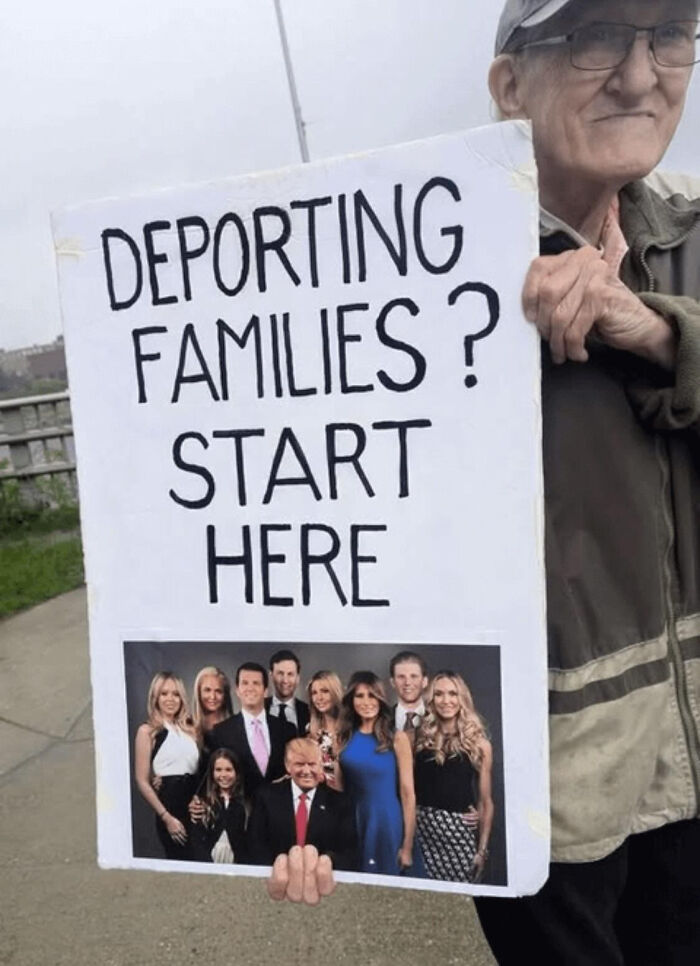 Man holding sign with photo and message about deporting families, representing chaotic good acts done in their own way.