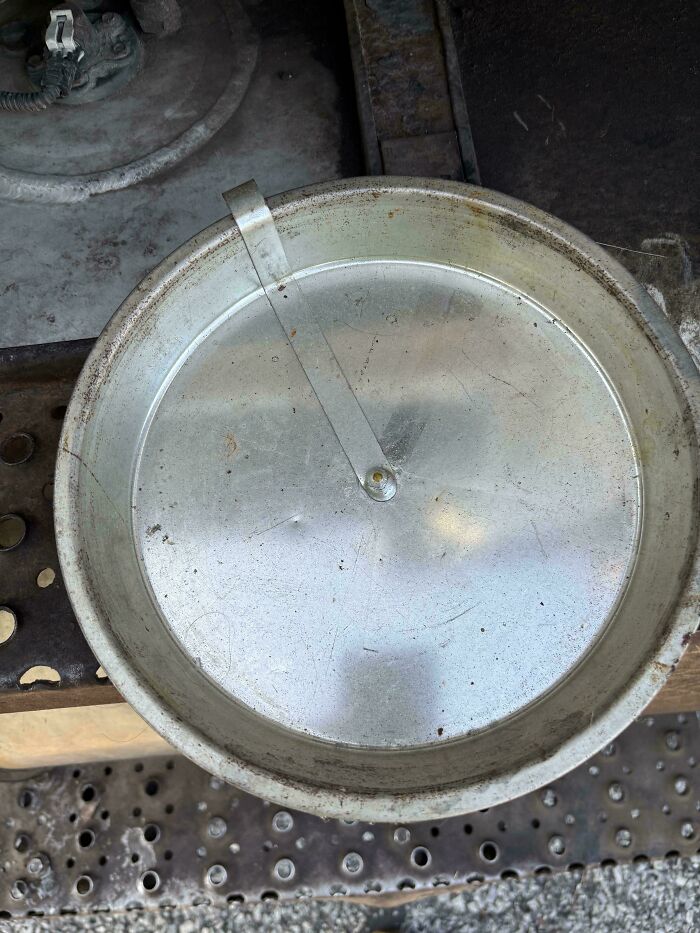 Old metal cooking pot lid with a handle, showing wear and rust, evoking nostalgia to make you feel old as heck.