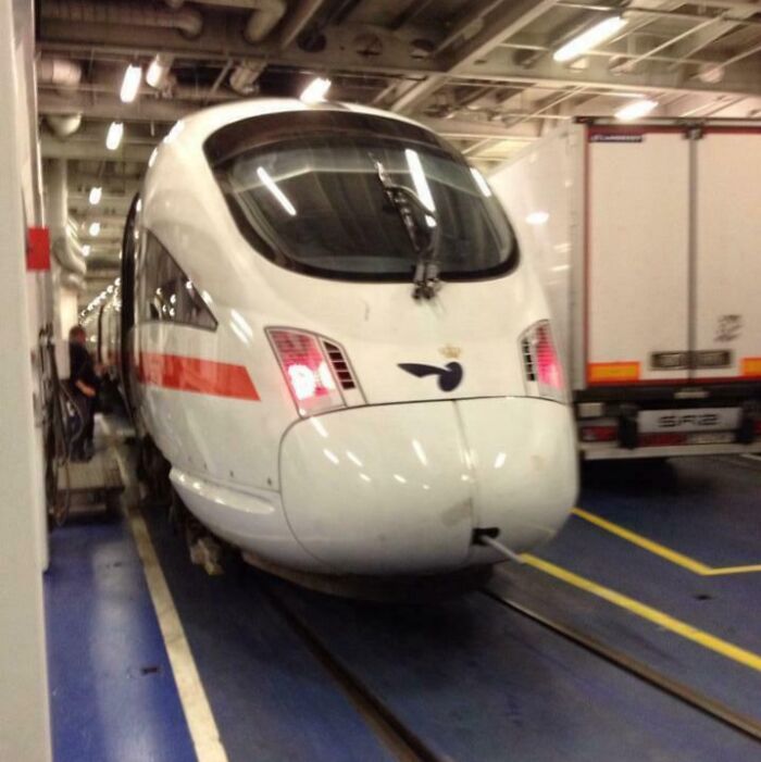 High-speed train parked inside a large ferry vehicle deck, showcasing unique Danish transportation and travel innovations.