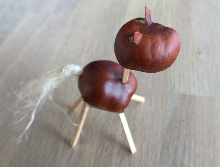 Handmade chestnut animal figure with wooden stick legs and a tail, illustrating creativity in Danish culture.