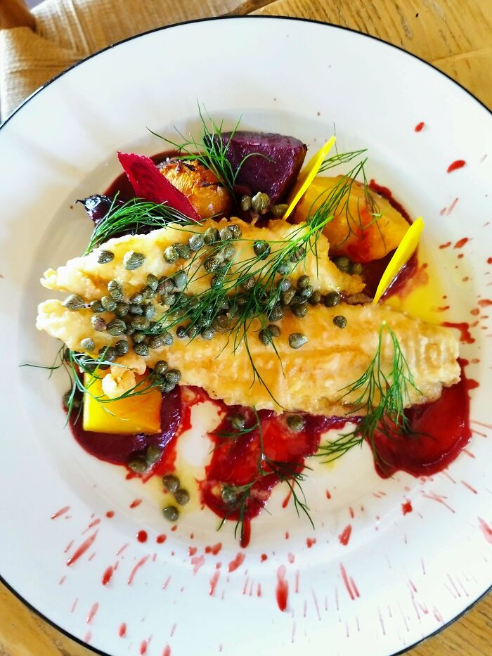Plated gourmet meal featuring sliced meat with sauce and vegetables, illustrating fancy kitchen tricks to elevate cooking skills.