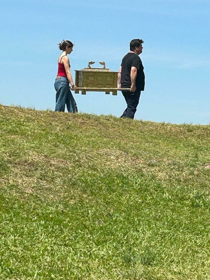 Two people walking on a grassy hill carrying a mysterious ornate box, one of 46 curious things people discovered. Two people walking on a grassy hill carrying a mysterious ornate box, one of 46 curious things people discovered.