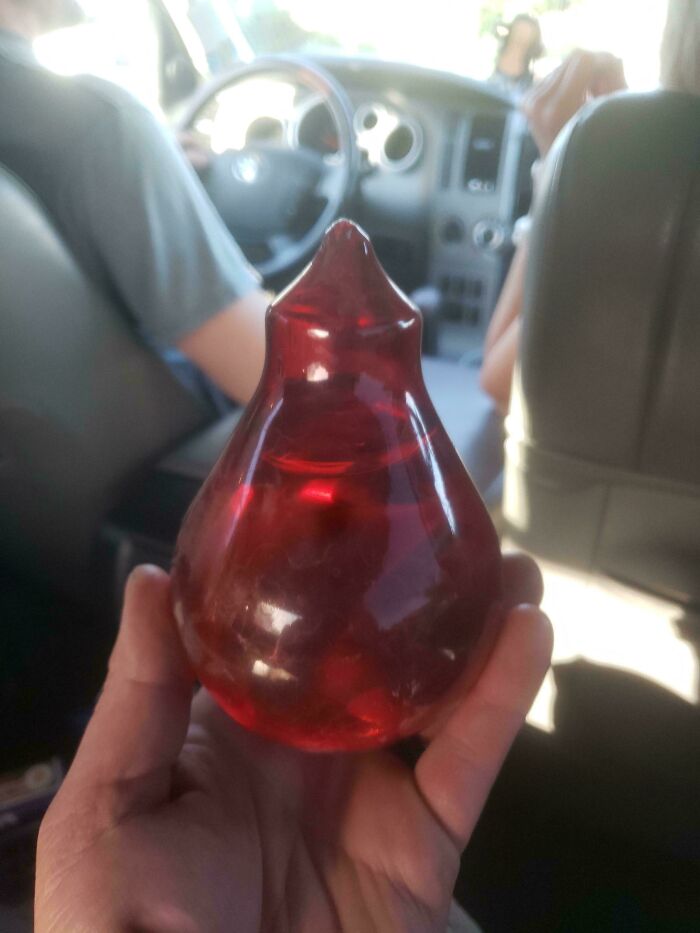 Hand holding a mysterious red translucent object inside a car, one of 46 curious things people discovered with no idea what they were. Hand holding a mysterious red translucent object inside a car, one of 46 curious things people discovered with no idea what they were.