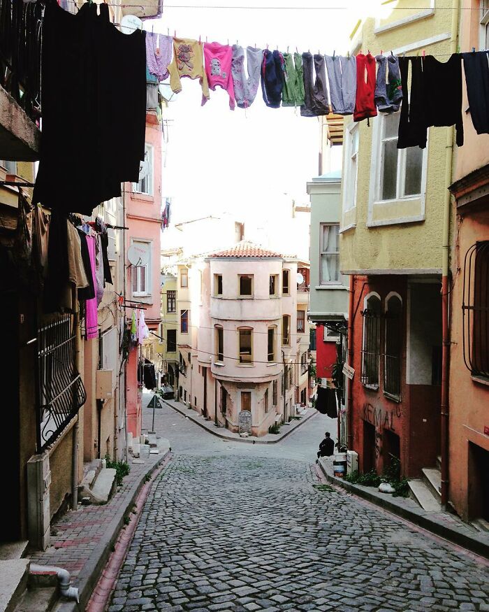 Cobbled street in Turkey with colorful buildings and laundry hanging, showcasing the real candid side of life.