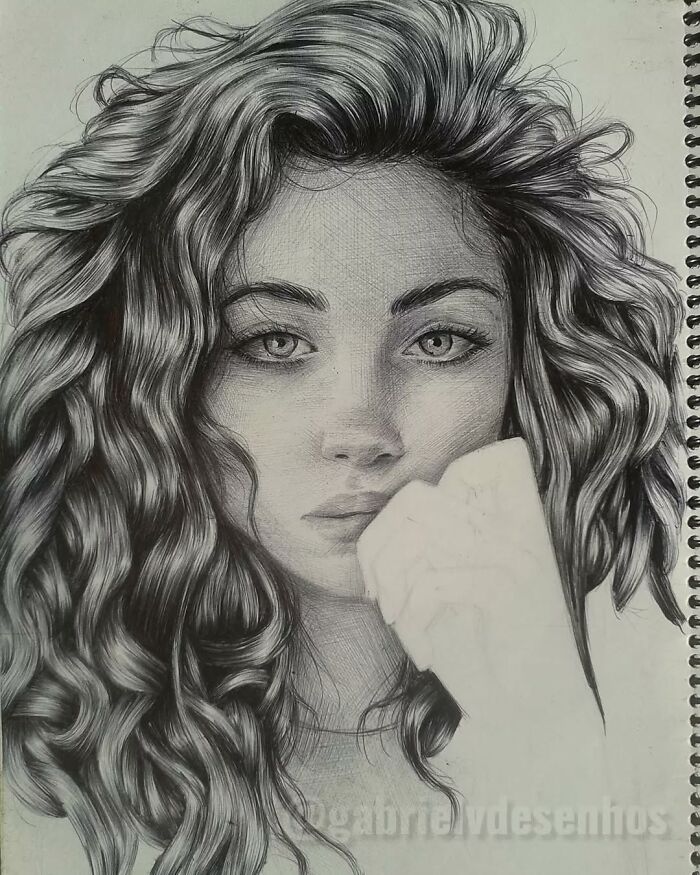 Detailed ballpoint pen portrait of a woman with curly hair, showcasing realistic drawing technique that looks like a photograph.