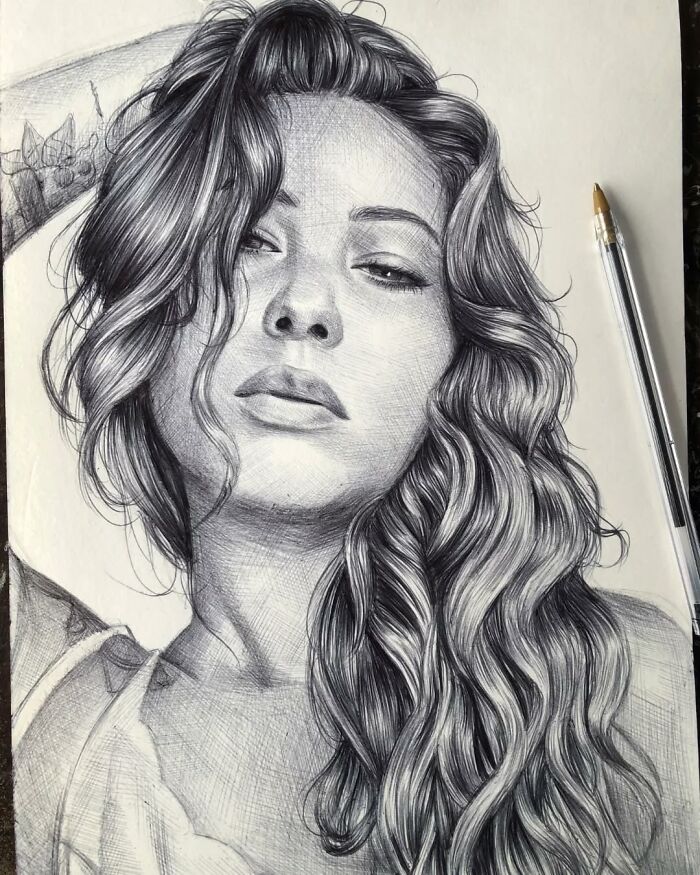 Realistic ballpoint pen portrait of a woman with long wavy hair, showcasing detailed shading and lifelike features.