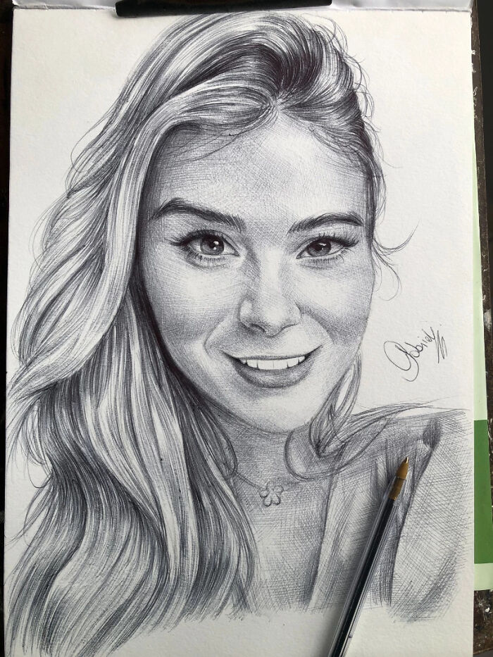 Realistic ballpoint pen portrait of a smiling woman with long hair, showcasing detailed shading and texture in the drawing.