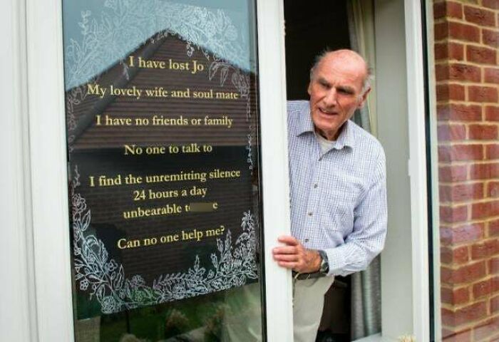 Elderly man standing by a door with a heartfelt message, illustrating heartwarming stories to cleanse negativity.