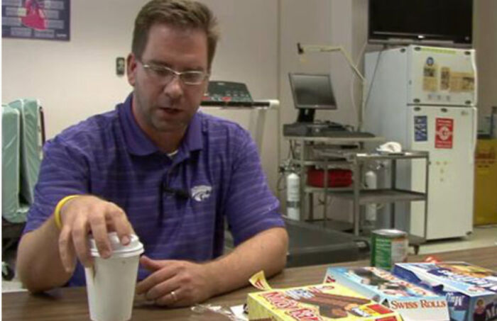 Man in purple shirt sitting at table with heartwarming stories items and food to brighten a day and cleanse negativity.