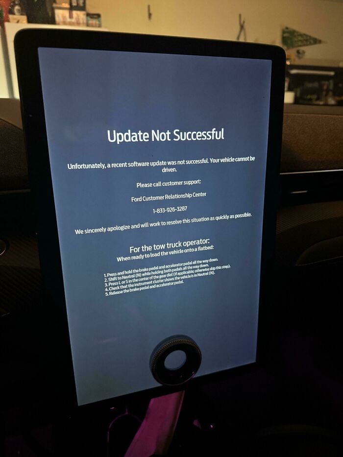 Car dashboard screen displaying update not successful message warning vehicle cannot be driven in a dystopian nightmare scene.
