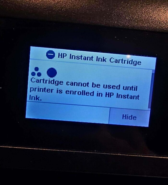 Printer screen showing error message about HP Instant Ink cartridge enrollment in a dystopian nightmare scene.