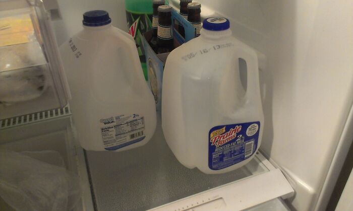 Empty milk jugs left inside a fridge next to beer bottles, illustrating awful roommates and their inconsiderate habits.