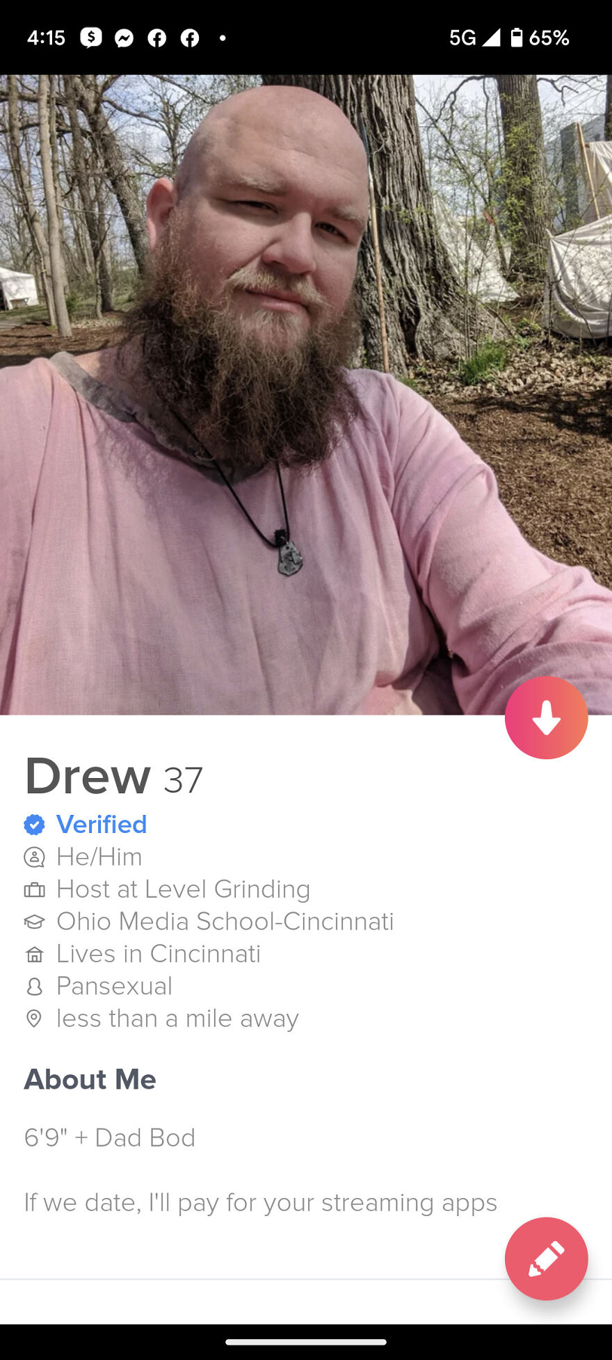 Bearded man in pink shirt taking an outdoor selfie for Tinder profile showcasing best Tinder bios for guys.