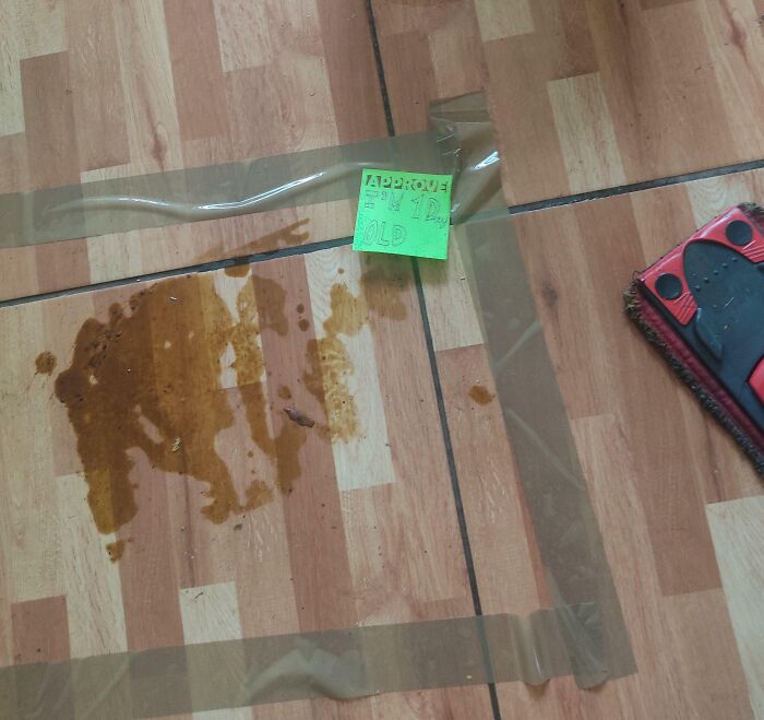 Spilled liquid taped off on floor with a sticky note, illustrating awful roommates and enraging roommate behavior.