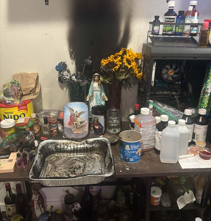 Burnt wall and damaged items on cluttered desk showing awful roommates' cooking disaster and neglect.