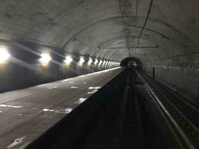 Dimly lit empty tunnel with railroad tracks, illustrating unsettling conditions related to jobs that should pay more.