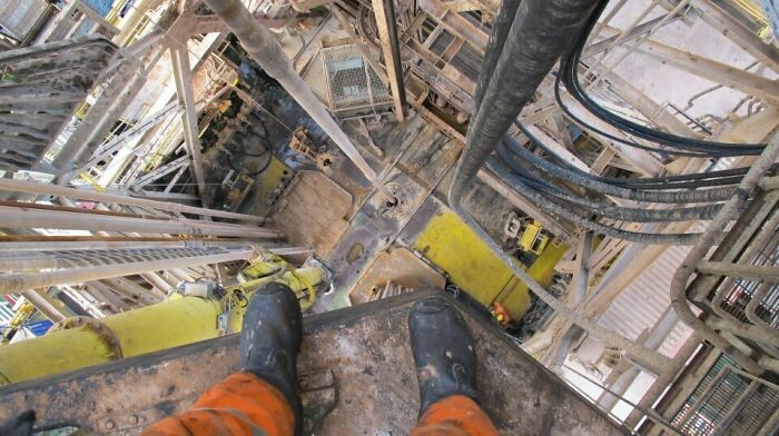 View from a worker’s boots inside a dirty industrial setting showing a creepy and unsettling job site environment.