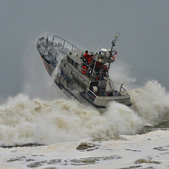 Coast Guard crew navigating rough seas on a small rescue boat showing one of the jobs that should pay more with unsettling conditions.