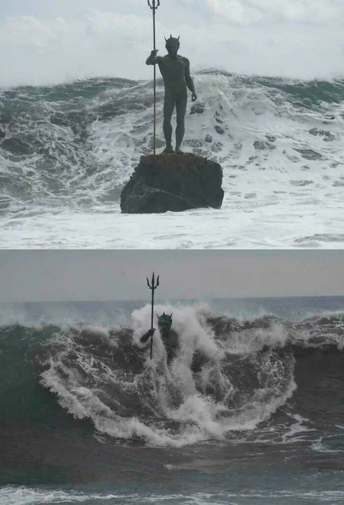 Amazing Photos: bronze Neptune statue on rock holding trident as towering waves crash around it in stormy ocean