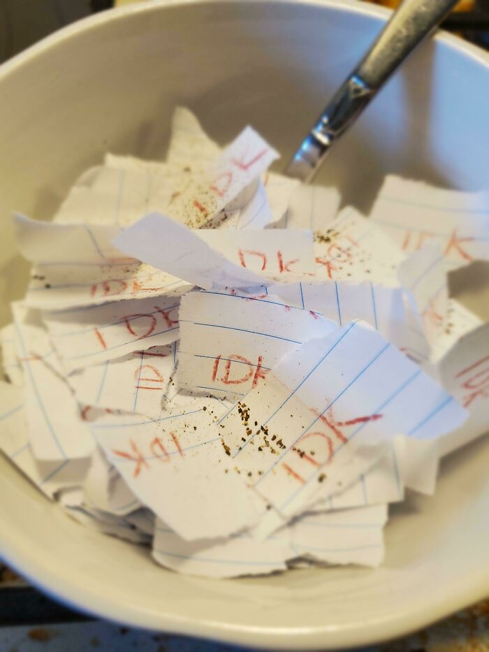 Bowl filled with torn pieces of paper and a spoon, capturing a simple moment of moms being their amazing wholesome selves.